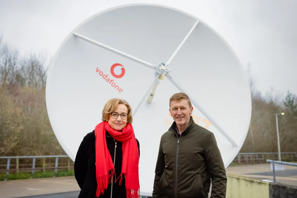 Margherita Della Valle y Tim Peake frente a la antena terrestre de Vodafone en Newbury.